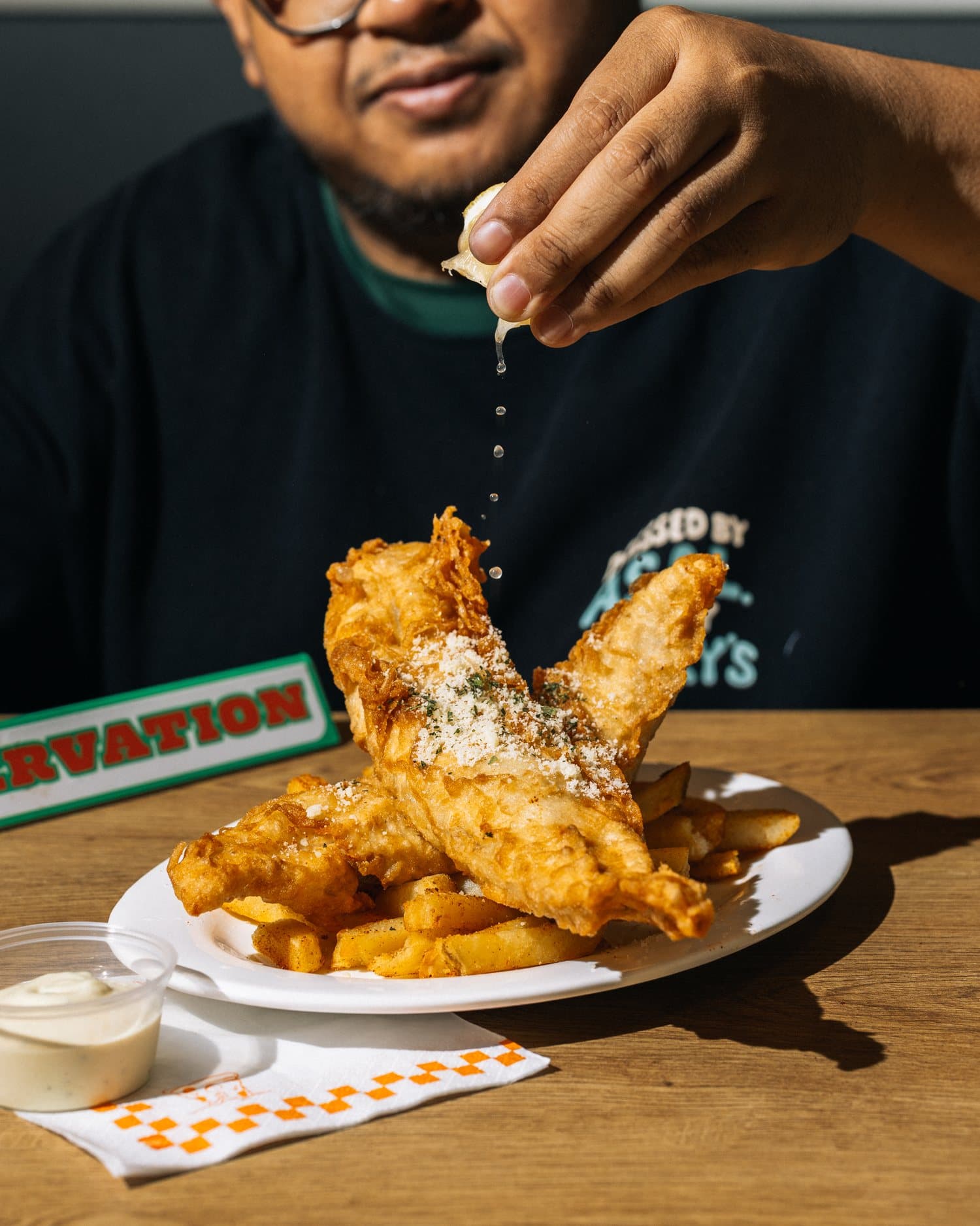 A guest digging into fish and chips in-store